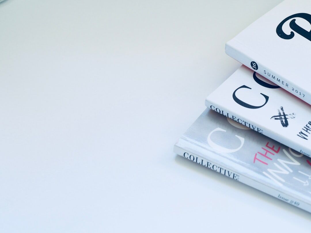 Stack of magazines and a coffee cup on a desk